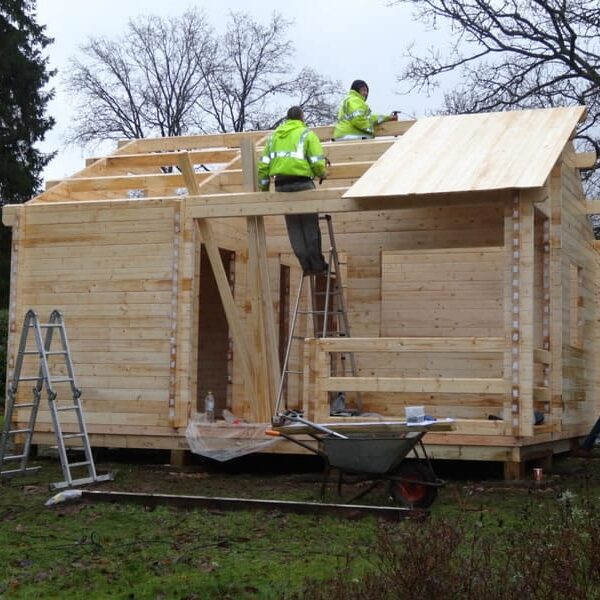 Roof being fitted and the whole build nearly complete of the log cabin