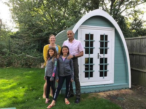 Family standing with the garden gym pod they built